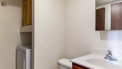 A spacious living room with plush seating and a dining area, showcasing the cozy and welcoming interiors of North River Place Apartments