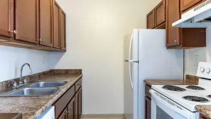 A fully equipped kitchen featuring white appliances, spacious cabinetry, and a tiled floor, offering a perfect space for meal preparation and gatherings.