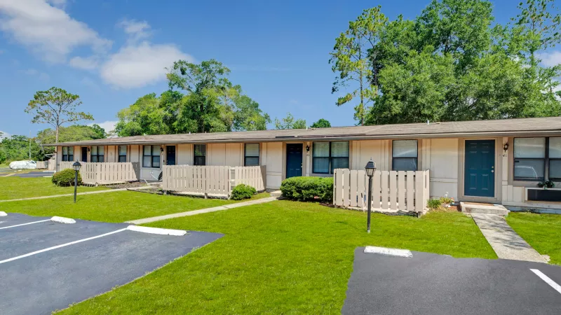 A welcoming ramp leading to a residential building with an American flag and a "Welcome Center" sign in the foreground.