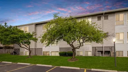 Vibrant exterior of Rosehill Plaza under a colorful evening sky with neatly trimmed grass and trees.