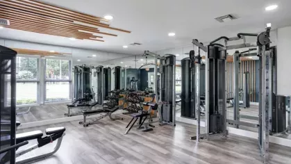 A well-equipped fitness center featuring strength training machines and mirrors.