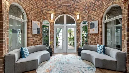 A stylish brick atrium with curved gray seating and vibrant decorative elements.