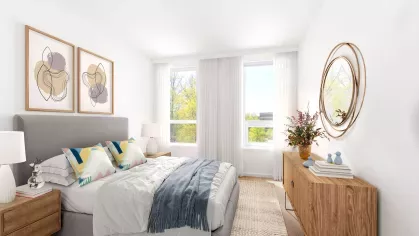 Comfortable bedroom with a cozy bed, elegant nightstand lamps, and a desk near a large window.