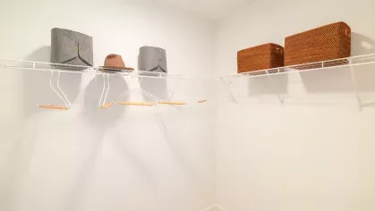 Spacious walk-in closet featuring wire shelving with storage bins and clothing hangers.