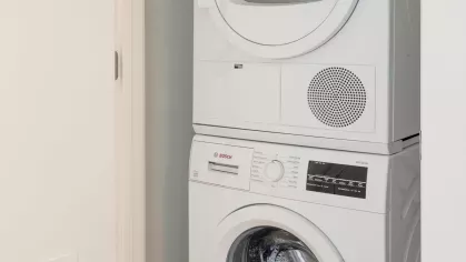 In-unit Bosch stacked washer and dryer neatly tucked into a closet space.