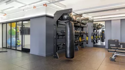 A spacious fitness center with state-of-the-art cardio machines, weight training equipment, and full-length mirrors, offering a comprehensive workout experience for residents.