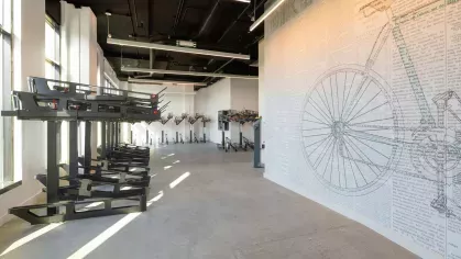 A spacious fitness center with state-of-the-art cardio machines, weight training equipment, and full-length mirrors, offering a comprehensive workout experience for residents.