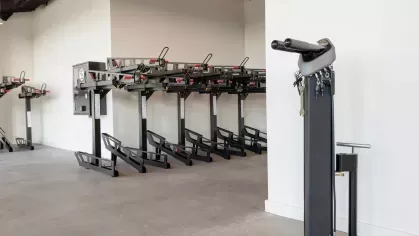 A spacious fitness center with state-of-the-art cardio machines, weight training equipment, and full-length mirrors, offering a comprehensive workout experience for residents.