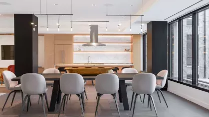 A state-of-the-art chef’s kitchen with a marble-topped island, bar stools, and high-end appliances in an open-concept design.