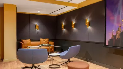 A cozy media room with a large projection screen, plush seating, and contemporary lighting, perfect for private movie nights.