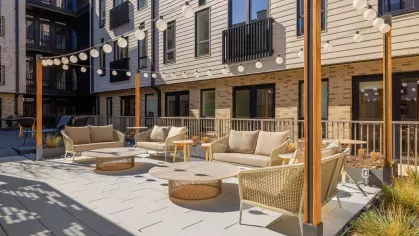 Relaxing outdoor space with contemporary patio furniture and elegant landscaping at The Edmund Apartments.