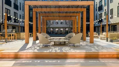 Relaxing outdoor space with contemporary patio furniture and elegant landscaping at The Edmund Apartments.