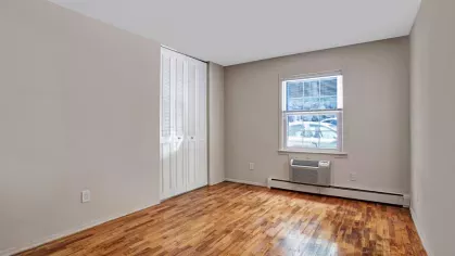 Bright bedroom with hardwood flooring, a large window for natural light, and ample closet space, ideal for restful nights.