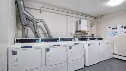 Laundry facility at The Manors Apartments with multiple modern washers and dryers for resident convenience.