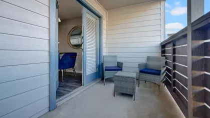 Private balcony with seating, offering a relaxing outdoor space at The Maxwell Apartments in San Antonio, TX.