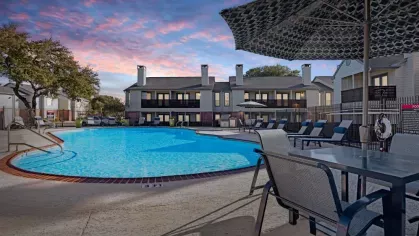 A twilight view of the swimming pool area at The Maxwell Apartments, featuring soft lighting and an inviting atmosphere for evening relaxation.