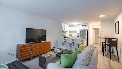 An inviting living space with a large TV, contemporary furniture, and light decor.