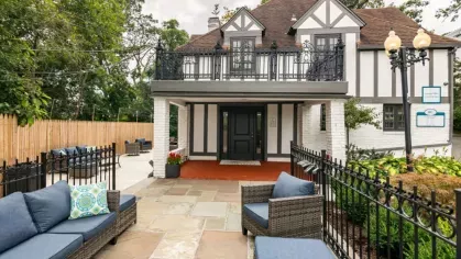 A charming Tudor-style building with a courtyard featuring outdoor seating.