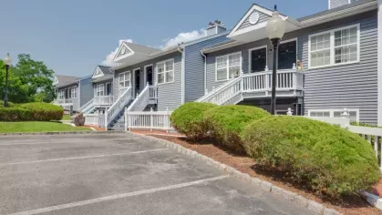 A residential building with well-maintained landscaping and a paved parking lot.