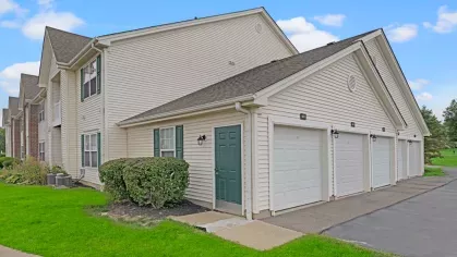 A row of attached garages with green doors and convenient access, ensuring secure parking for residents.