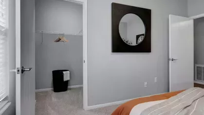 Walk-in closet adjacent to a bedroom in Trotter's Landing Apartments, showcasing ample storage space with clean design and neutral tones.