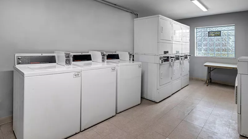 Community laundry room with multiple washers and dryers, offering a clean and organized space for residents.