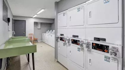 Well-maintained laundry room with washing machines, dryers, and folding stations for resident convenience.
