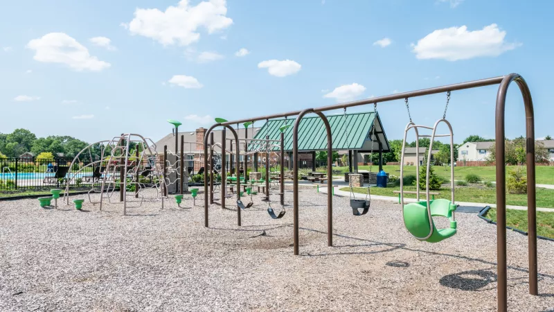 "Playground at Worthington Meadows Apartments with climbing structures, swings, and open grassy areas for children."