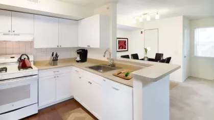 A fully equipped kitchen with warm cherry wood cabinetry, stainless steel appliances, and an open layout for easy entertaining.