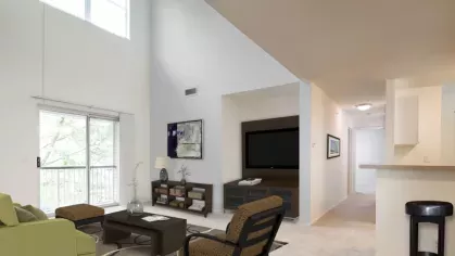 A chic living and dining area with elegant furnishings, modern decor, and large windows that brighten the space.