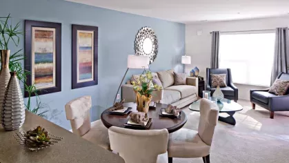 A stylish loft apartment with an open-concept design, showcasing a bright living room, modern kitchen, and dining area with high ceilings.