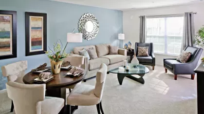 A stylish loft apartment with an open-concept design, showcasing a bright living room, modern kitchen, and dining area with high ceilings.