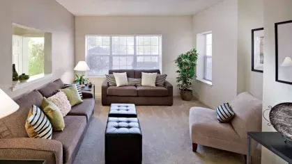 Cozy living room with plush sofas, stylish accent pillows, and large windows that let in plenty of natural light.