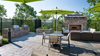 Outdoor fireside lounge with seating and BBQ grilling stations, providing a cozy and scenic setting for social gatherings.