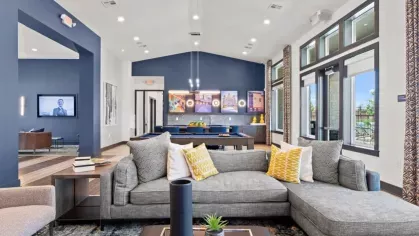 A spacious clubhouse with a contemporary sectional sofa, vibrant decor, and pool table, designed for social gatherings and relaxation.