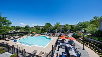 Aerial view of the community’s expansive pool area, complete with lounge chairs, shaded seating, and a grilling station for outdoor enjoyment.
