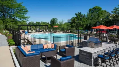 Poolside lounge area featuring modern outdoor seating with vibrant blue cushions, offering a comfortable and stylish place to relax.