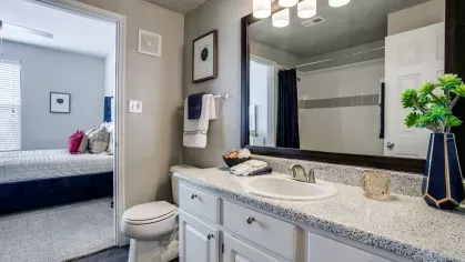 A clean and well-lit guest bathroom with white cabinetry and stylish décor.