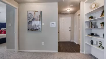 A large walk-in closet with hanging racks and shelving for storage, connected to a cozy bedroom.