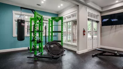 A gym weightlifting section with modern equipment and a striking green and black design.