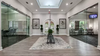 A sophisticated lobby with a stylish skylight, glass partitions, and elegant artwork.