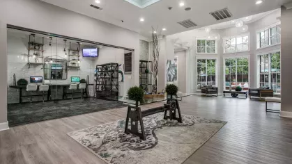 A sophisticated lobby with a stylish skylight, glass partitions, and elegant artwork.