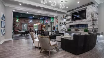 A stylish clubhouse with shuffleboard, a bar area, and arcade games, creating a fun atmosphere.