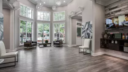 A bright, open lobby with floor-to-ceiling windows, modern seating, and decorative accents.