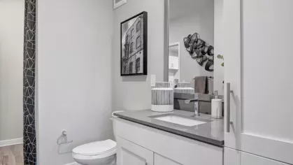 A modern bathroom with a sleek vanity, a large mirror, and a neutral color scheme.