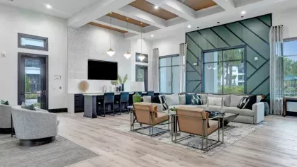 A well-designed lounge featuring plush seating, a mounted TV, and a dining area, ideal for socializing and relaxation.