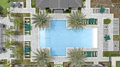 Top-down view of a symmetrical swimming pool area with lounge chairs, shaded seating, and neatly arranged palm trees.