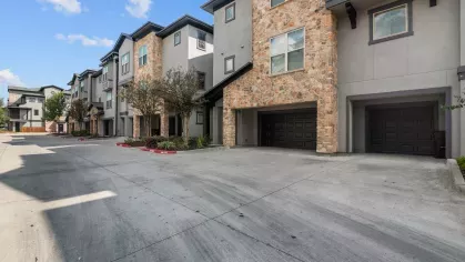 Private, attached garages with stone-accented exteriors and ample driveway space in the community.