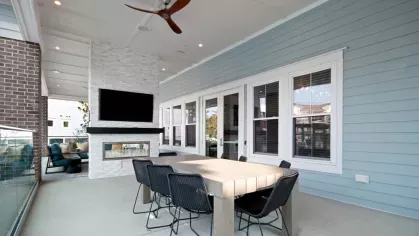 Outdoor dining area with a ceiling fan and a flat screen TV