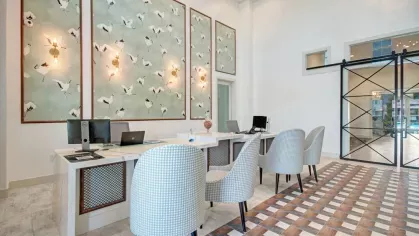 Modern co-working and relaxation space with stylish purple seating, unique lighting fixtures, and a refined interior design.